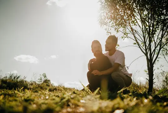 Ett par som sitter ute i naturen en sen sommareftermiddag.