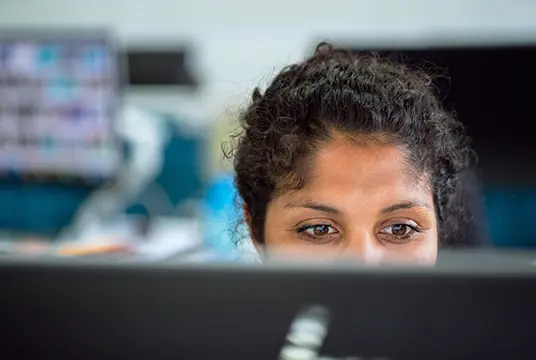 Kvinna framför en datorskärm.