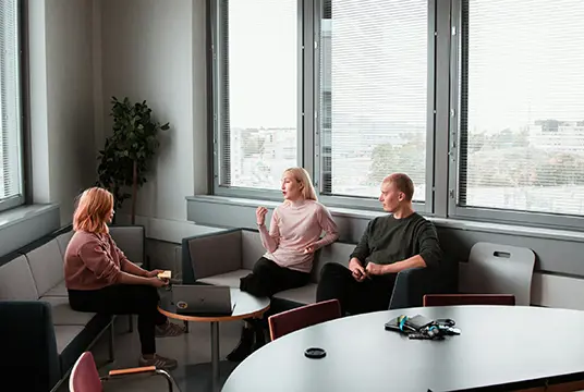 Tre personer som sitter och diskuterar.