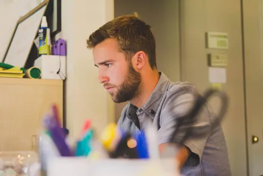 Fundersam man framför en datorskärm.